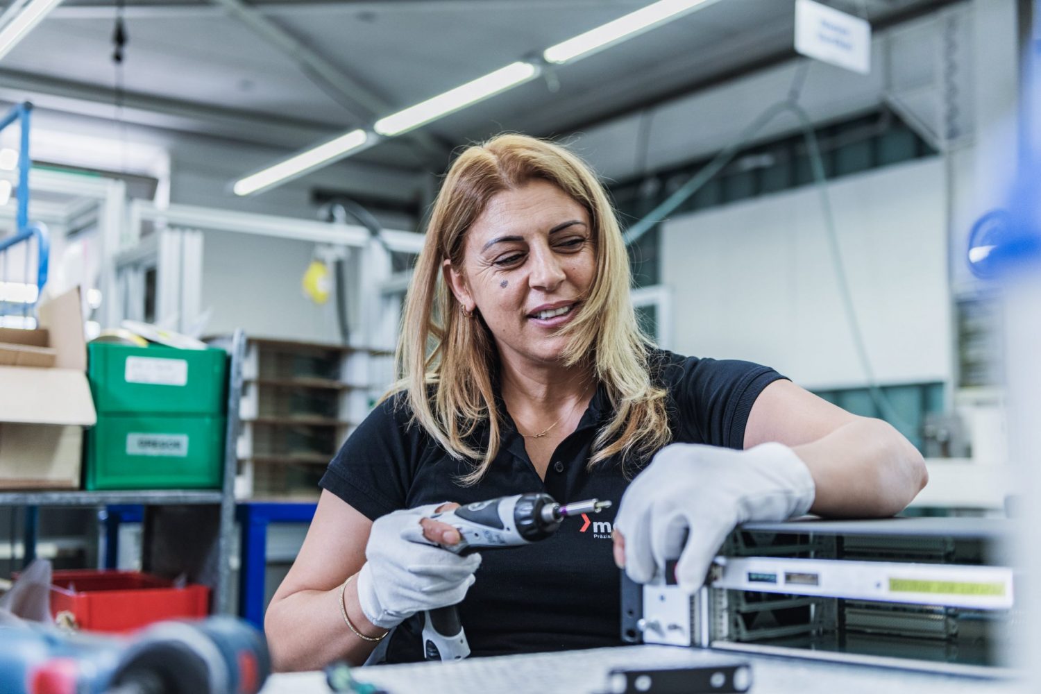 montage_baugruppentraeger Mitarbeiterin der Montageabteilung schraubt mit einem Akkuschrauber einen Baugruppenträger zusammen