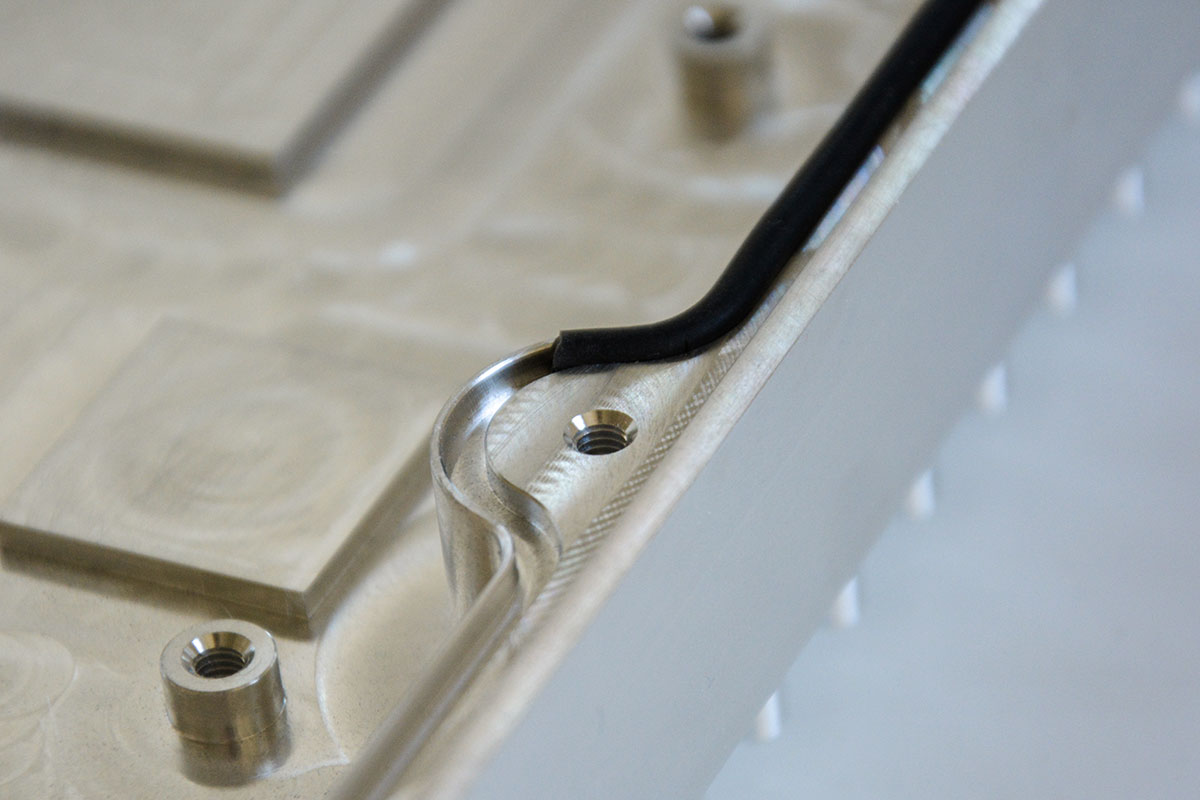 Dichtschnur, die in eine umlaufende, kleine Auskerbung eines Gehäuseteils aus Aluminium eingepresst ist.