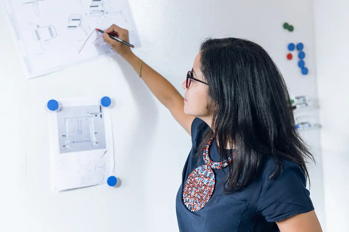 Designerin markiert etwas mit einem Stift an einem Whiteboard
