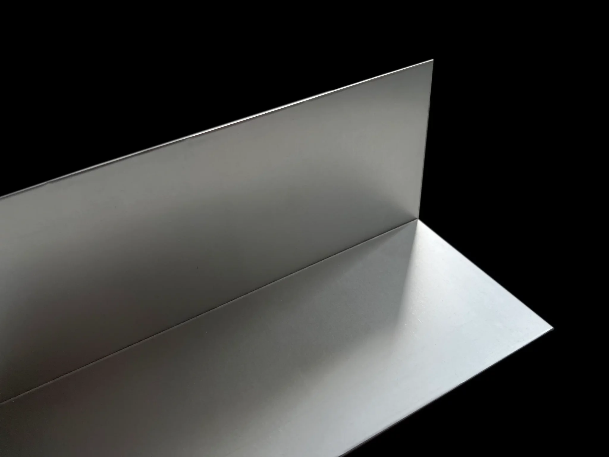 L-Profil / Winkelprofil aus Stahl liegt vor schwarzem Hintergrund
