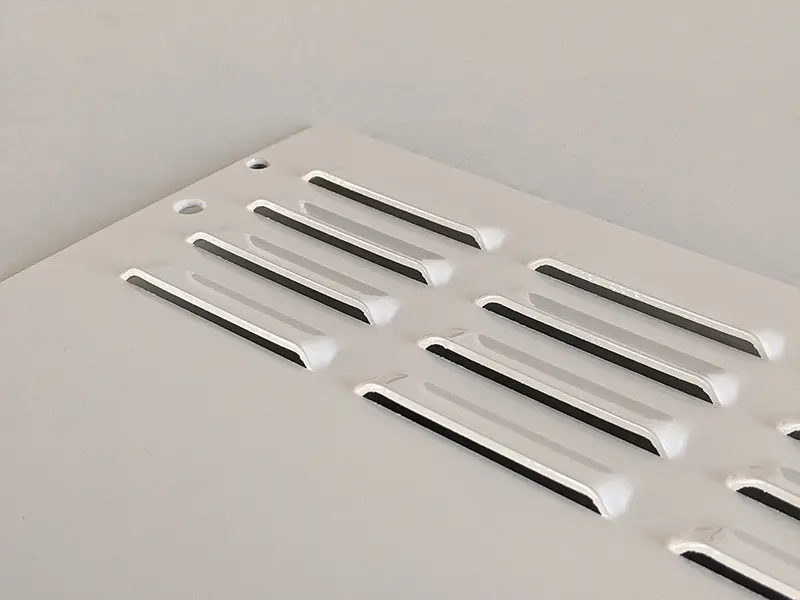 Gestanzte Lüftungsschlitze in Kiemenform in einem Blechteil