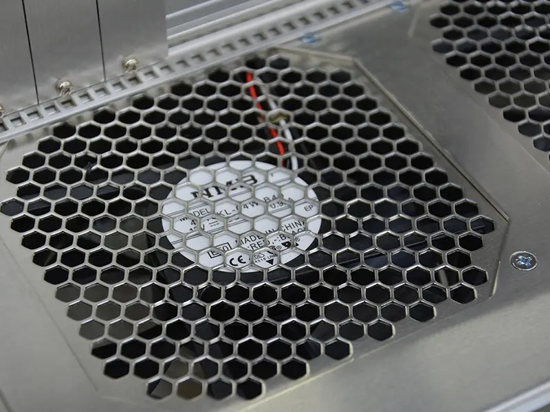 Schutzblech mit Lüftungslöchern montiert vor einem Lüfter