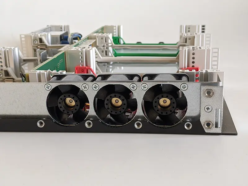 Drei seitlich montierte Lüfter an einem geöffneten elektronischen Baugruppenträger