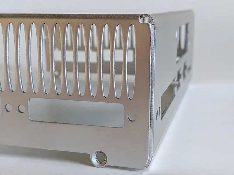 Metallgehäuse mit vertikalen, ovalen Lüftungsschlitzen an der Rückseite